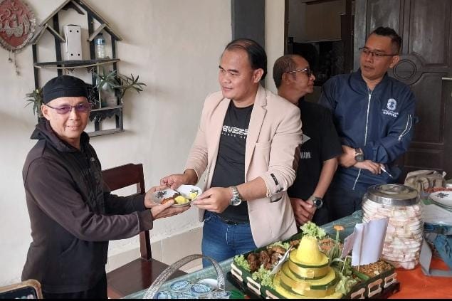 Ketua PWI OKU Yudi Saputra SH memberikan potongan tumpeng kepada wartawan senior di PWI OKU Armin Pani dari majalah gradasi.