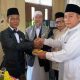 Kepala Kemenhaj OKU Abdul Mu'is memberikan potongan tumpeng kepada Kabag Kesra OKU Zauhari. Pemkab OKU memfasilitasi CJH OKU 8 kendaraan di musim haji 2026.