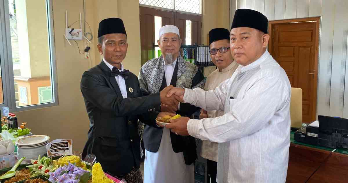Kepala Kemenhaj OKU Abdul Mu'is memberikan potongan tumpeng kepada Kabag Kesra OKU Zauhari. Pemkab OKU memfasilitasi CJH OKU 8 kendaraan di musim haji 2026.