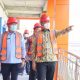 Bupati OKU Selatan bersama jajaran meninjau pembangunan gedung rumah sakit dengan mengenakan helm proyek dan rompi keselamatan.