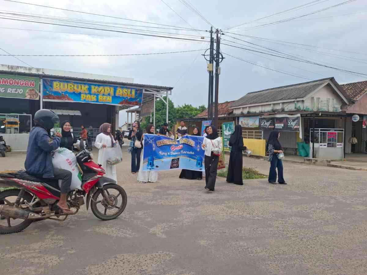 Pembagian takjil oleh pegawai King Karaoke kepada pengguna jalan di Desa Gumawang, OKU Timur.