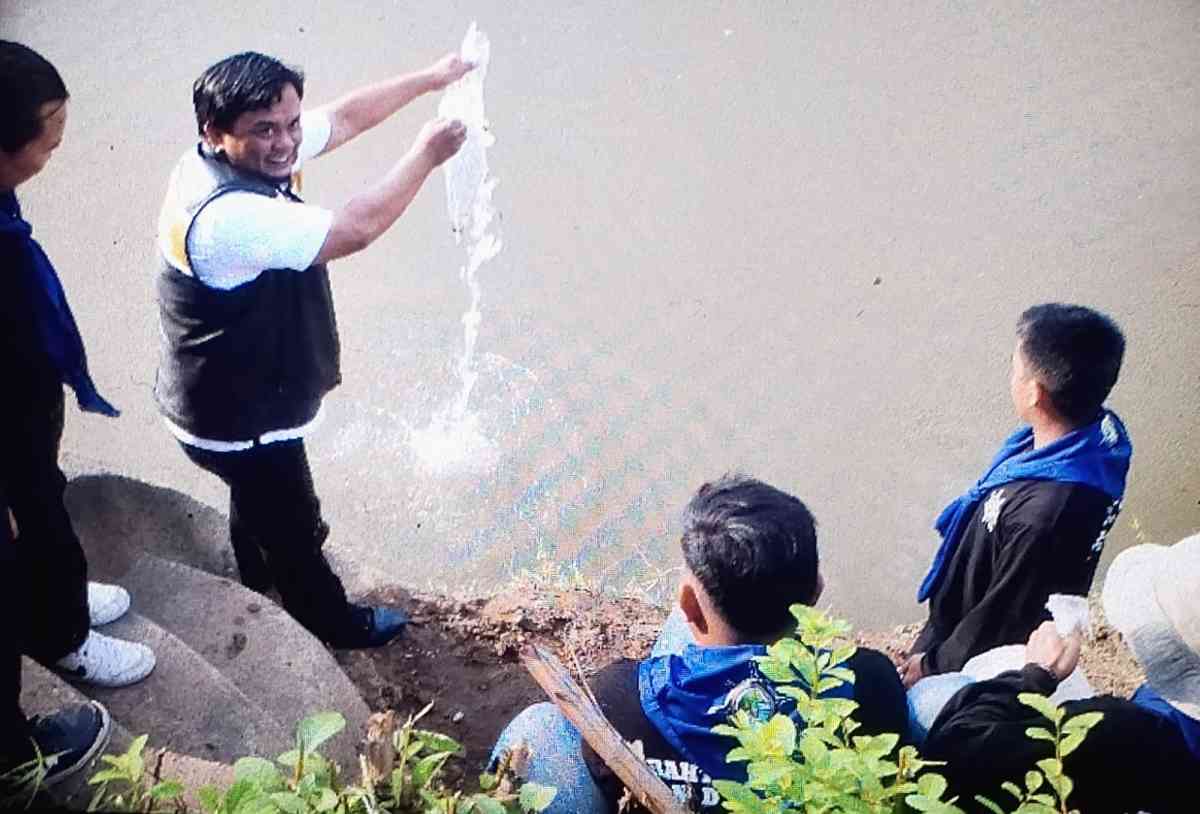 M Saleh Tito melepas benih ikan di sungai Ogan. 