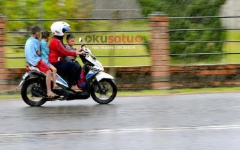 Pengendara sepeda motor bonceng tiga melintas di jalan raya dan terancam sanksi tilang polisi